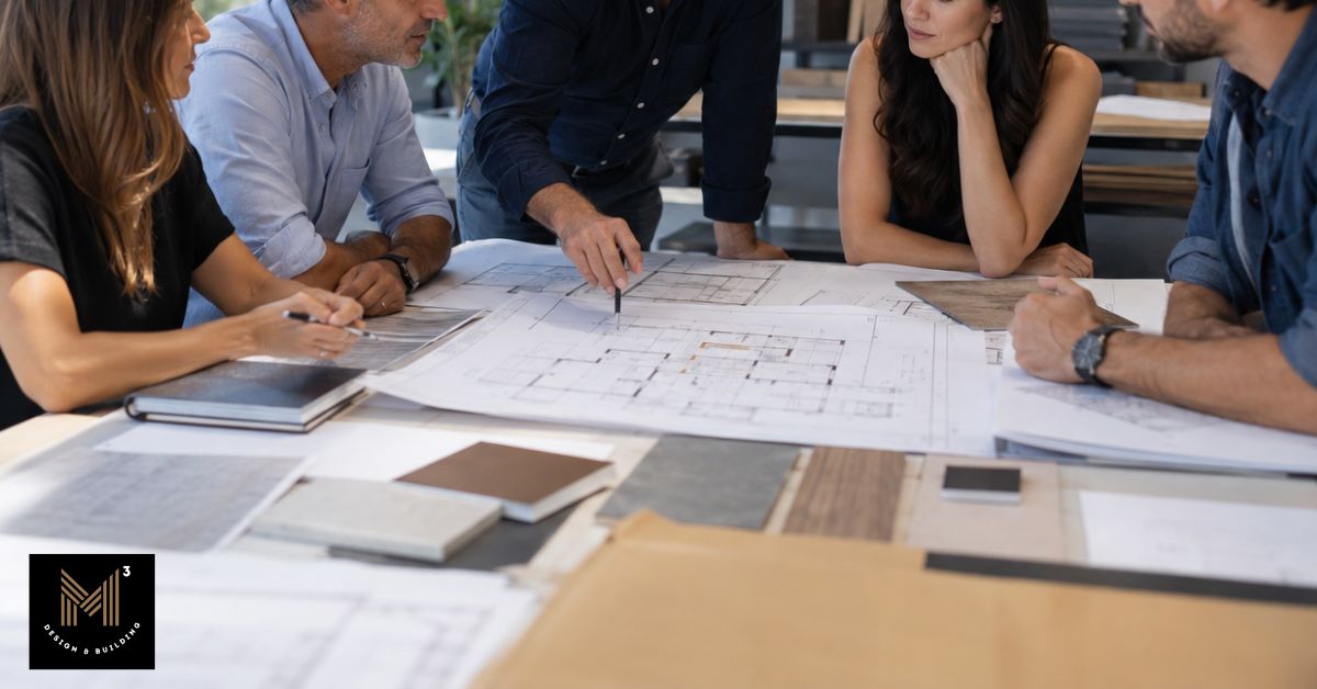 Architects, engineers, construction professionals, and a homeowner reviewing architectural plans and material samples together during a collaborative value engineering meeting in a modern design-build office.